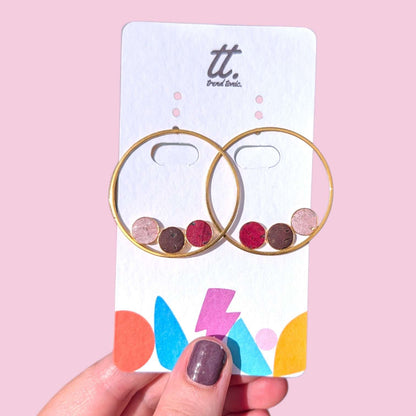 a hand holding a card with earrings