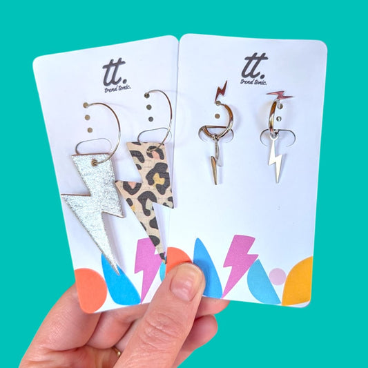 a hand holding a pair of earrings