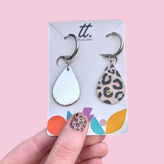 a hand holding a pair of earrings