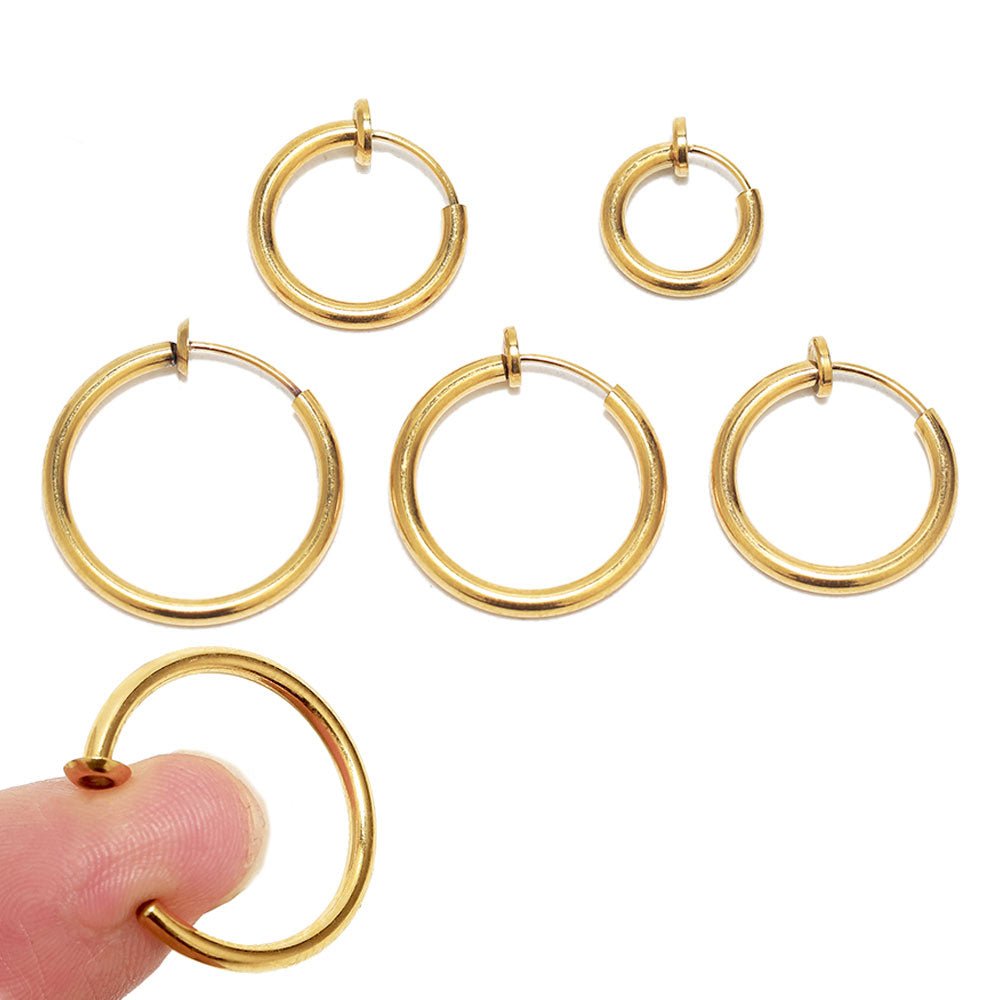 a finger pointing at a gold hoop earring
