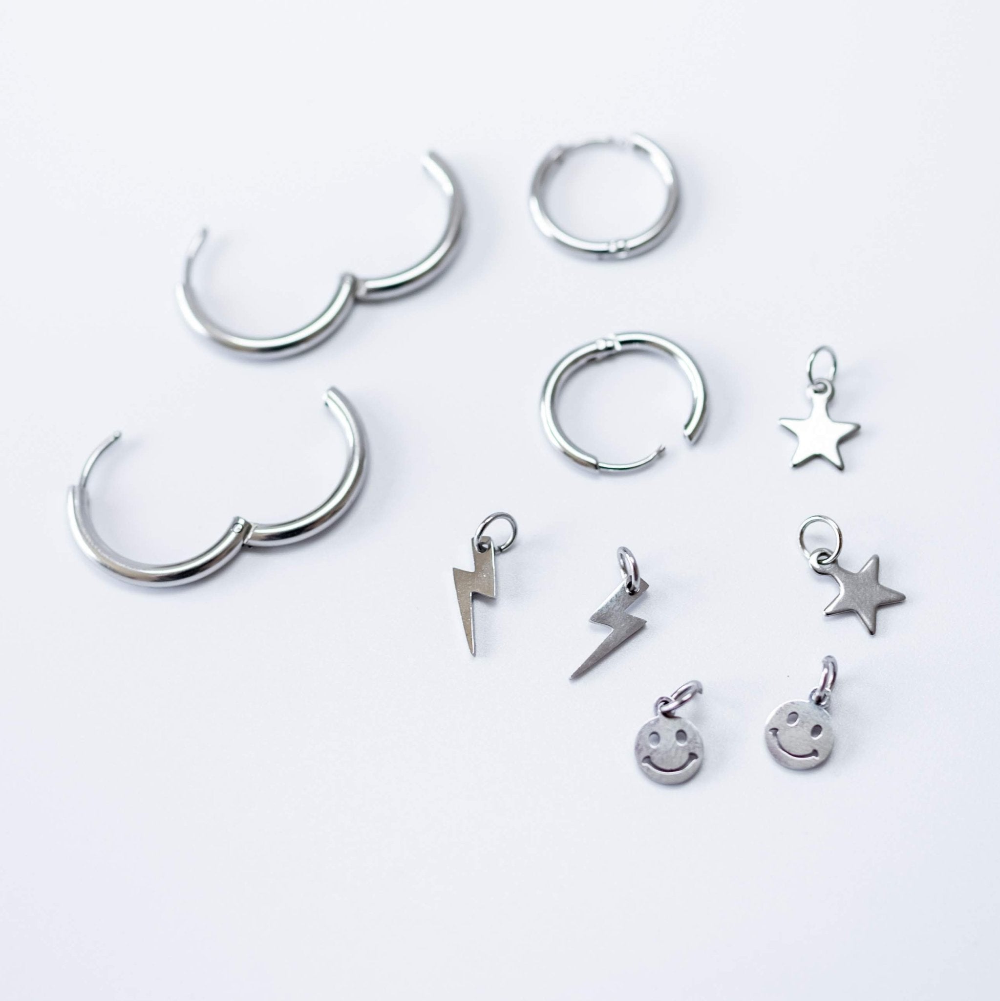 a group of silver earrings