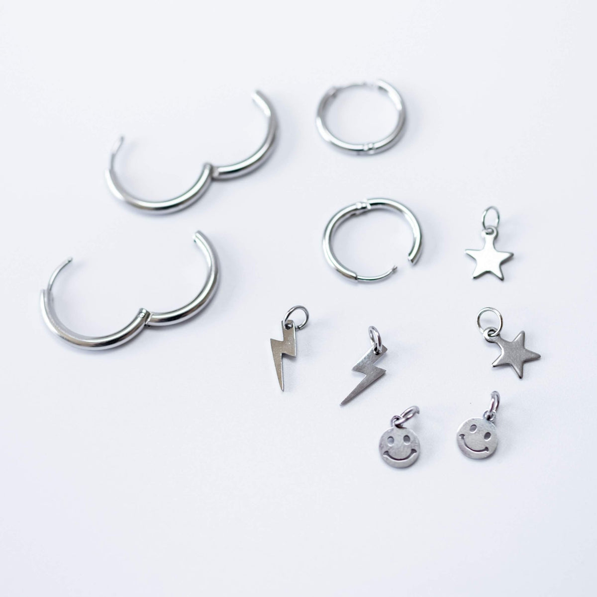 a group of silver earrings